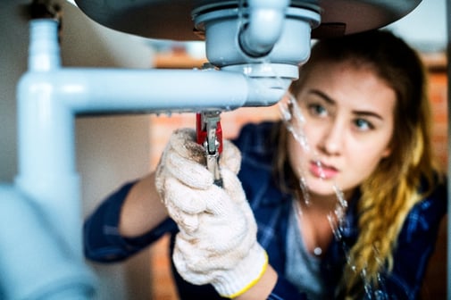 woman fixing sink